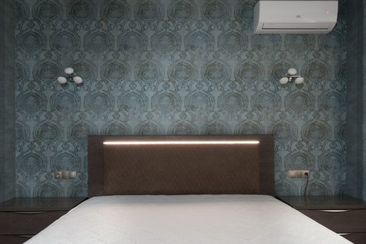Contemporary bedroom with a dark damask feature wall and backlit headboard