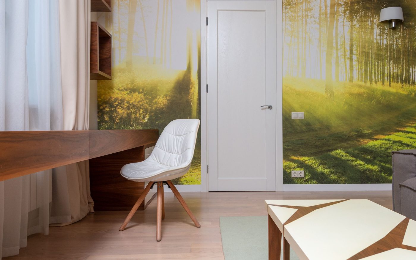 Home study with a full-wall forest mural wallpaper beside a walnut desk
